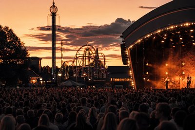 Konsertpublik vid en utomhusscen under en sommarnatt i Sverige
